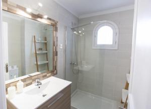 La salle de bains blanche est pourvue d'une douche et d'un lavabo. dans l'établissement Apartamento SARA en el complejo Teguisol, à Costa Teguise