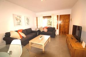 sala de estar con sofá y TV en Beach - Sun apartament - Sol y Playa Puerto del Carmen, en Puerto del Carmen