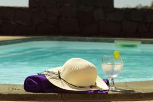 un sombrero y una copa de vino junto a la piscina en Beach - Sun apartament - Sol y Playa Puerto del Carmen, en Puerto del Carmen