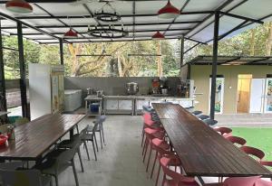 een groep houten tafels en stoelen in een restaurant bij Collection O 90858 Bentong Wellness Homestay Midland in Kampong Sungai Chendarawi