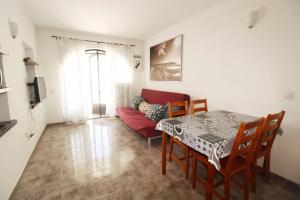 a living room with a table and a red couch at Dúplex Vista Mar Puerto Del Carmen in Puerto del Carmen