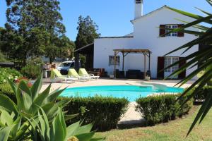 una piscina di fronte a un edificio bianco di Batalha House a Ponta Delgada