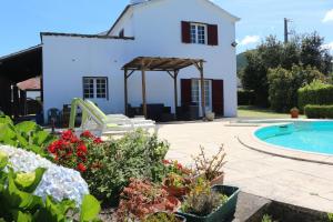 a villa with a swimming pool and a house at Batalha House in Ponta Delgada