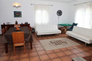 un soggiorno con tavolo e mobili bianchi di Batalha House a Ponta Delgada Altre 22 foto