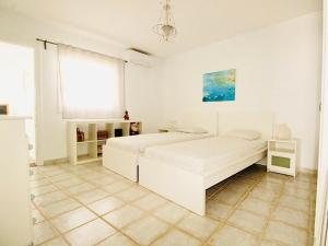 a white bedroom with a bed and a window at Luxury Villa Alfred in Puerto del Carmen +31 photos