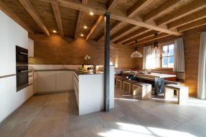 een keuken met houten plafonds en een tafel en stoelen bij Chalet Chäserrugg in Wildhaus