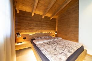 a bed in a room with a wooden wall at Chalet Chäserrugg in Wildhaus