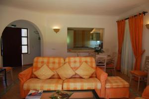 a living room with an orange couch and a table at Pestana Golf Resort - T2 71d in Carvoeiro
