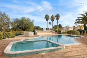 a swimming pool in a yard with palm trees at Pestana Golf Resort - T2 71d in Carvoeiro