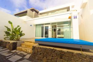 a house with a blue couch on the side of it at Luxury Villa Rincon del Mar- Old Town - Puerto del Carmen in Puerto del Carmen