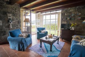 a living room with two blue chairs and a coffee table at Casa da Lagoa in Sete Cidades