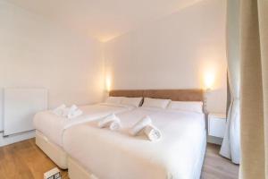 um quarto branco com 2 camas e toalhas brancas em LovelyLoft Rafael 3º em Alicante