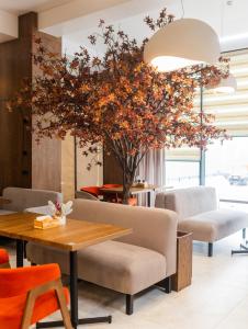a dining room with a table and a tree at Elena Spa Resort in Bukovel