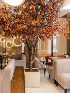 a tree in a room with chairs and a table at Elena Spa Resort in Bukovel