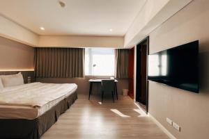a hotel room with a bed and a table at 瑞昊國際商旅-家美瑞品-JiaMei Hotel in Taipei