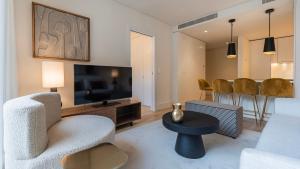 sala de estar con silla, TV y mesa en Deluxe 1 BDR Apartment W/ Pool View by LovelyStay, en Lisboa