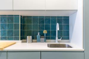 a kitchen with a sink and green tiles at Estudio moderno y acogedor en Madrid Rio nº1 in Madrid
