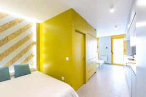 a bedroom with a bed with a yellow wall at Estudio moderno y acogedor en Madrid Rio nº1 in Madrid