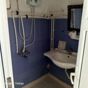 een badkamer met blauwe tegels en een wastafel bij Sultanköy Apart in Marmaraereglisi