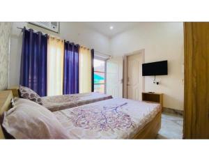 1 dormitorio con 2 camas y TV en Saini Guest House , Gurdaspur, en Gurdāspur