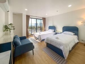 um quarto de hotel com duas camas e um sofá em Goldsmith Bangkok Residence em Bangkok