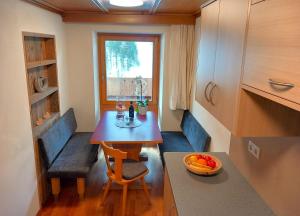 une petite salle à manger avec une table et une fenêtre dans l'établissement Residence Ferienheim Folie, à Melago