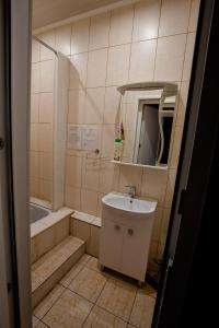 庫爾斯克的住宿－格斯特沃大教堂斯特羅加諾維克公寓式酒店，一间带水槽和浴缸的小浴室