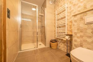 La salle de bains est pourvue d'une douche et de toilettes. dans l'établissement Perle Blanche - Brand New 2 bedroom apartment perfectly located, à Chamonix-Mont-Blanc