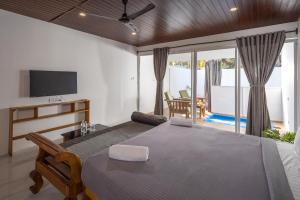 ein Schlafzimmer mit einem großen Bett und einem TV in der Unterkunft Crystall Goa Turquoise Edition in Patnem