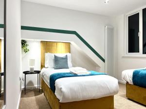 a bedroom with a bed with a green stripe on it at Perfect Stay For Family & Contractors With Free Parking in Luton