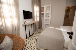 a bedroom with a bed and a flat screen tv at Riad Coconut in Marrakech