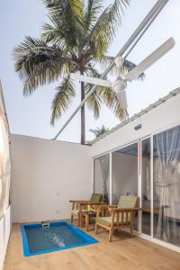 帕特嫩的住宿－Crystall Goa Turquoise Edition，客厅里的棕榈树,带有游泳池