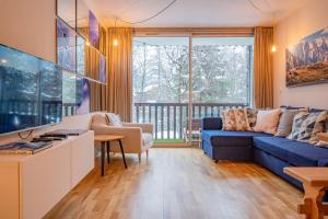 sala de estar con sofá azul y ventana grande en Apartment Arve, en Chamonix-Mont-Blanc