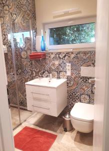 a bathroom with a white sink and a toilet at Mediterran-Skandinavisch-2 in Burgthann