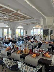 Hotel El Puntazo I في موجاكار: غرفة طعام مع طاولات وكراسي ونوافذ