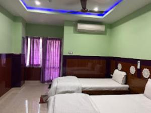 1 dormitorio con 2 camas y luz azul en Hotel 707 Bhubaneswar, en Bhubaneshwar