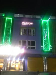 un edificio con luces verdes en el lateral. en Hotel 707 Bhubaneswar, en Bhubaneshwar