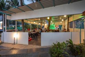 Crystall Goa Turquoise Edition في باتنيم: مطعم بجدران بيضاء وطاولة بها أضواء