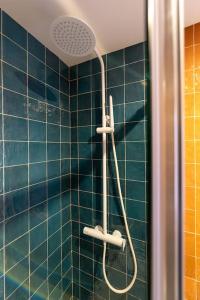 a blue tiled shower with a shower head in a bathroom at Estudio moderno y acogedor en Madrid Rio nº2 in Madrid