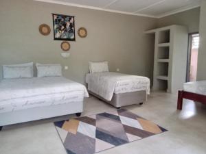 um quarto com 2 camas e um tapete em A Nice Homely 2- Bedroom House em Livingstone