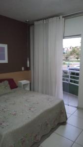 a bedroom with a bed and a large window at Village Aldeia das águas 1° Andar in Nossa Senhora das Dores +6 photos