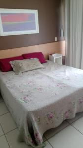 a bedroom with a bed with a white comforter at Village Aldeia das águas 1° Andar in Nossa Senhora das Dores