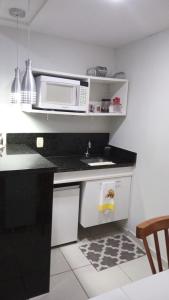 a kitchen with a microwave and a sink at Village Aldeia das águas 1° Andar in Nossa Senhora das Dores