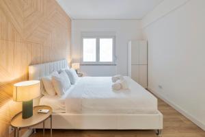 a bedroom with a white bed with a teddy bear on it at Setubal Horizon Apartment in Setúbal