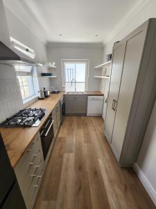 uma cozinha com armários brancos e um forno com placa de fogão em St James - Villa Mosselle em St James