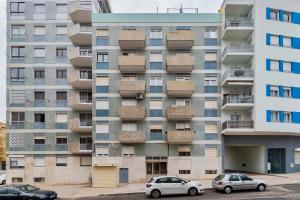 two cars parked in front of an apartment building at Setubal Horizon Apartment in Setúbal