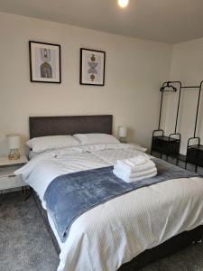 a bedroom with a large bed with towels on it at Quiet Hideout in Southend-on-Sea