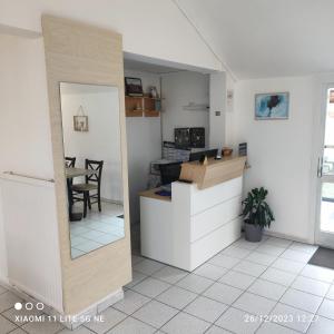 eine Küche mit einem Tisch und einem Spiegel im Zimmer in der Unterkunft ENOR Hôtel in Guingamp