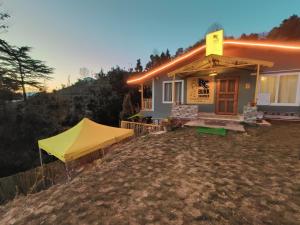 馬德史瓦的住宿－BUNK CHAMBER，前面有一个黄色帐篷的房子
