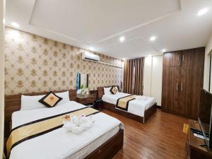 a hotel room with two beds and a television at Khách sạn Crown - Gần đại học Nông Lâm TN in Thái Nguyên +31 photos